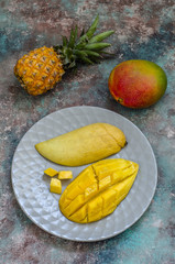 exotic fruits: sliced ​​Thai mango, pineapple and whole mango