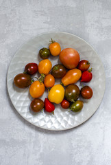 Colorful tomatoes on the grey surfase