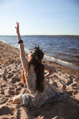 Young healthy woman practicing yoga on the beach at sunrise.