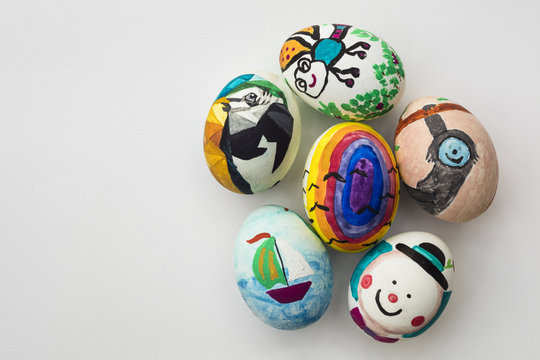 Detail of painted Easter eggs with different forms, cartoons and bright colors on isolated white background