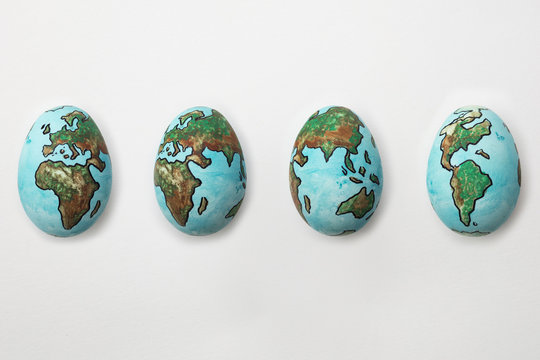 The World painted on eggs showing rotation cycle of the Planet Earth on isolated white background
