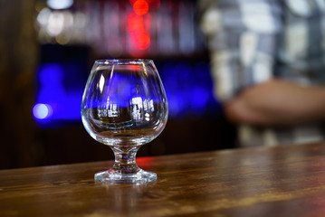 Clean empty glass on the bar. Blurred Background