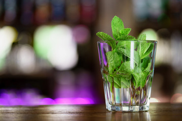 Fresh mint in a glass. Mojito cocktail at the bar on the table.