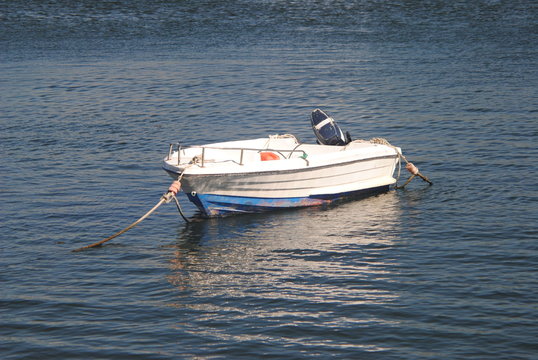 Barco pequeno a motor branco parado no rio