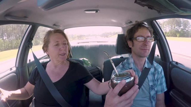Man and woman in a self driving autonomous car drinking mate