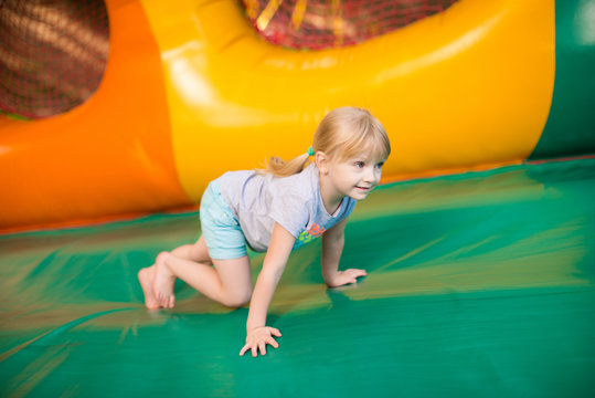 happy excited girl having fun on inflatable attraction playground. Moving up - Powered by Adobe