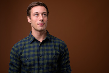 Young handsome man against brown background
