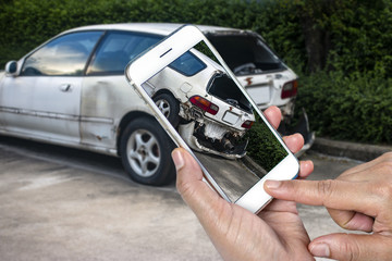 Close up hand of man holding smartphone and take photo of car accident
