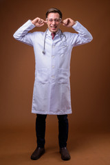 Young handsome man doctor wearing protective glasses against bro