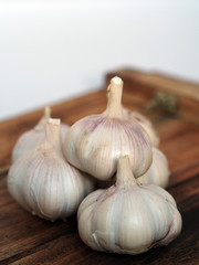 a bunch of garlic on a wooden board close up shot