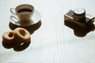 tea and retro camera and  donut on wood table