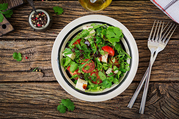 Salad with tomatoes, cheese and cilantro in sweet and sour sauce. Georgian cuisine. Healthy food. Top view. Flat lay