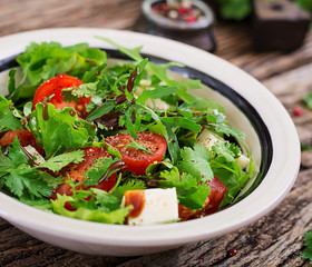 Salad with tomatoes, cheese and cilantro in sweet and sour sauce. Georgian cuisine. Healthy food.