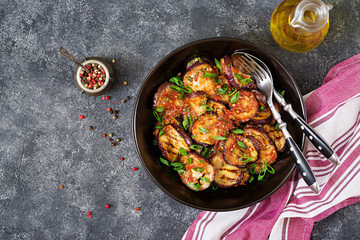 Eggplant grilled with tomato sauce, garlic, cilantro and mint. Vegan food. Grilled aubergine. Top view. Flat lay