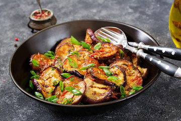 Eggplant grilled with tomato sauce, garlic, cilantro and mint. Vegan food. Grilled aubergine.