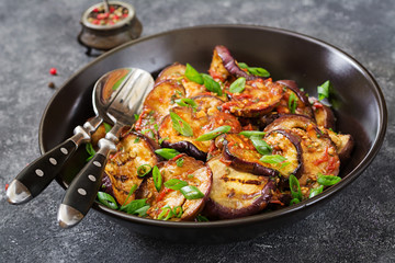 Eggplant grilled with tomato sauce, garlic, cilantro and mint. Vegan food. Grilled aubergine.