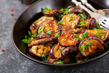 Eggplant grilled with tomato sauce, garlic, cilantro and mint. Vegan food. Grilled aubergine.