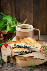 Panini sandwich with cheese and mustard leaves. Morning coffee. Village breakfast