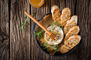 Baked cheese Camembert with rosemary and honey. Tasty food. Top view. Flat lay