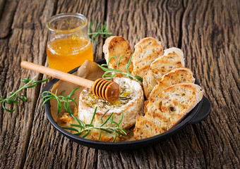 Baked cheese Camembert with rosemary and honey. Tasty food.