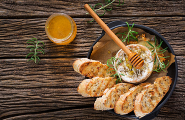 Baked cheese Camembert with rosemary and honey. Tasty food. Top view. Flat lay © timolina
