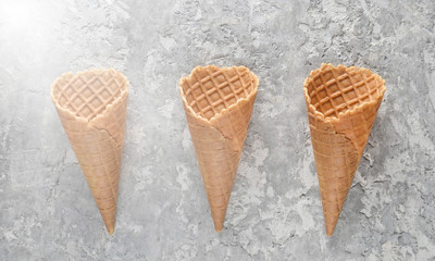 Three empty waffle horns on a concrete background. Top view, creative background, minimalist trend.