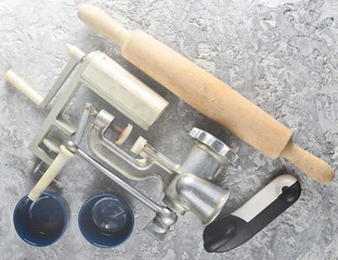 Kitchen tools on a gray concrete background. Roller, mincer, bowls. Top View.