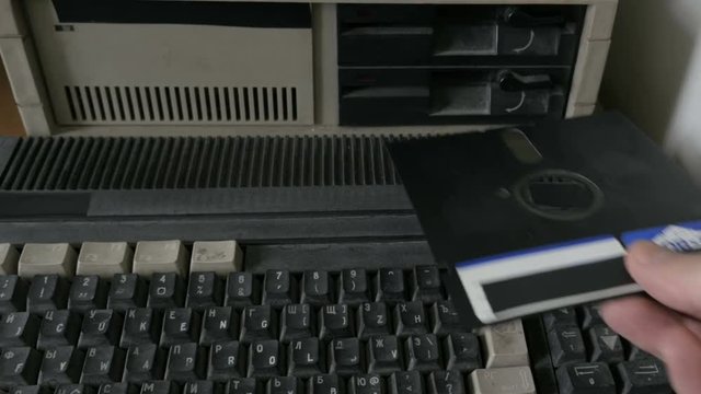Taking 5.25 inch diskette from floppy drive, close-up
