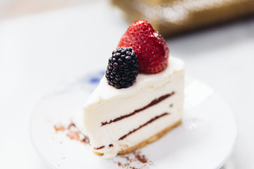 Slice of strawberry cheesecake topping with fresh strawberry and blackberry. Served with soda mocktail and syrup.