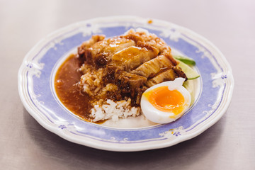 Crispy pork belly with rice pouring with gravy served with half of boiled egg.