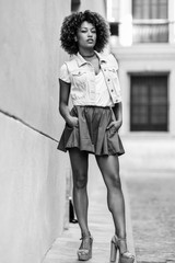 Young black girl, afro hairstyle, standing in urban background