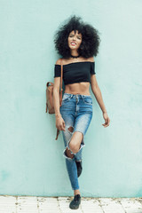 Young mixed woman with afro hair standing on the street