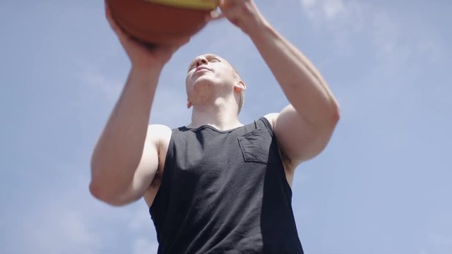 Basketball player taking a free throw outdoors, in slow motion