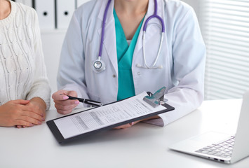 Doctor and patient, close-up of hands.  Physician talking about medical examination results. Medicine, healthcare and helping concept