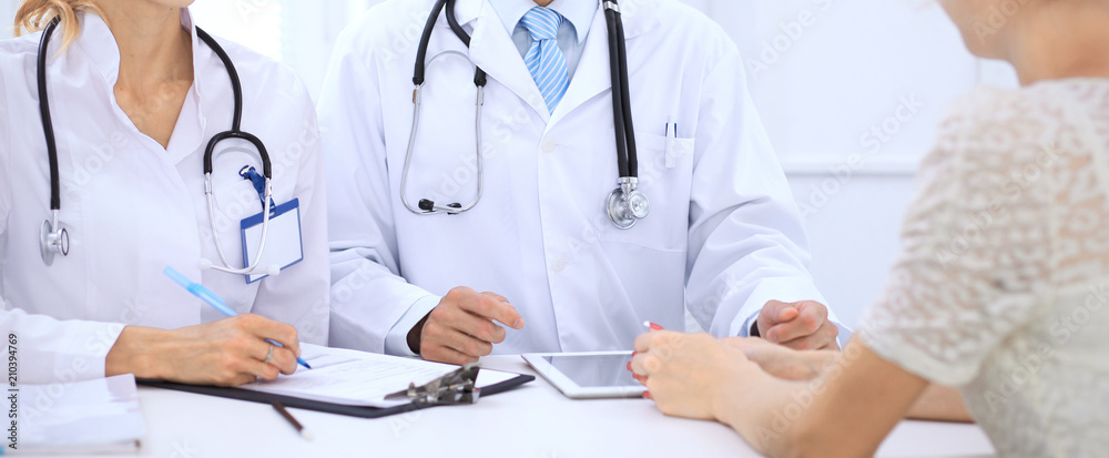 Wall mural doctor and patient talking while sitting at the table . concept of support and trust in medicine