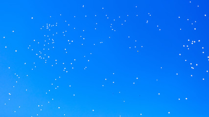 White balls flying in the blue sky