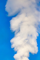 smoke from a pipe in the factory against a blue sky