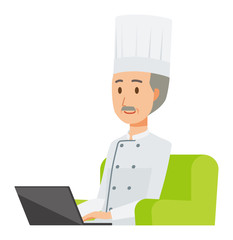An elderly male chef wearing a cook coat is sitting on a sofa and operating a laptop computer