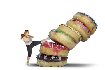 Overweight woman kicking donuts on studio