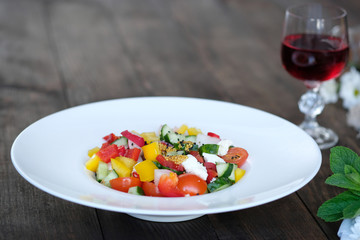 flowers, wine and salad from vegetables on old wooden table
