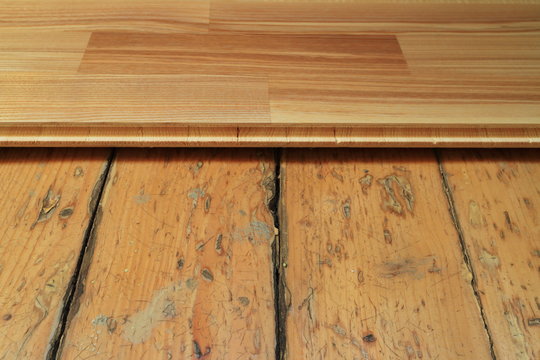An image of an old wooden floor and a new parquet board.