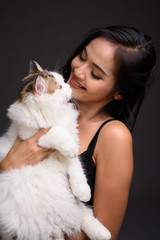 Young beautiful Asian woman holding Persian cat