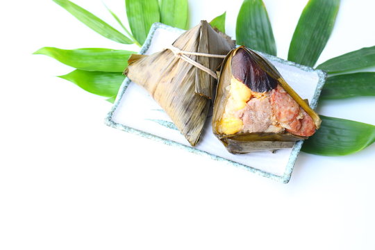 Zongzies on dish and bamboo leaves