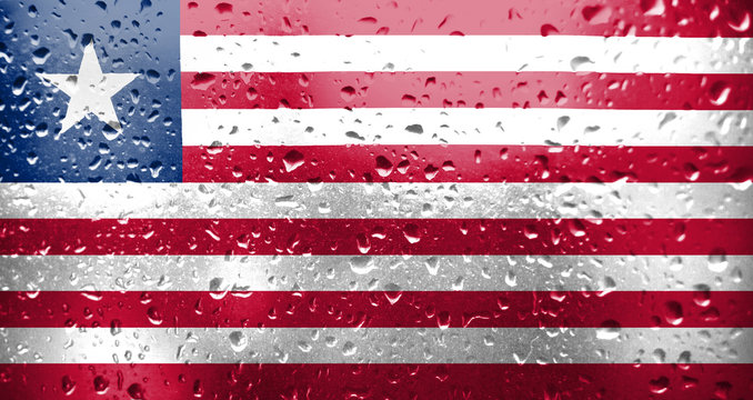Texture of Liberia flag on the glass with drops of rain.