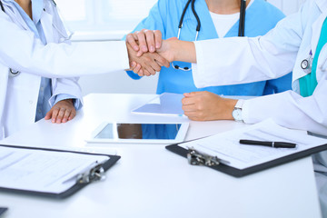 Two doctors shaking hands to each other at meeting. Teamwork and agreement in medicine