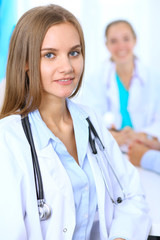 Fototapeta premium Happy doctor woman with medical staff at the background in hospital office