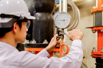 Engineer checking Condenser Water pump and pressure gauge , chiller water pump with pressure...