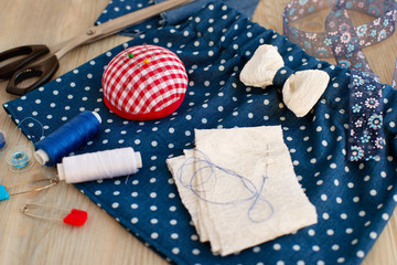 Sewing skirts for girls. Sew clothes for children from cloth with a pattern in polka dots. Tailoring scissors and objects for sewing.