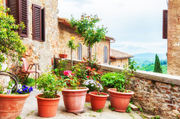 Obraz na płótnie Canvas Beautiful patio with flowers of the medieval building. San Gimignano, Tuscany, Italy