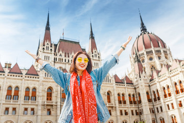 Happy asian casual woman student enjoying great view of the Parliament building in Budapest city,...